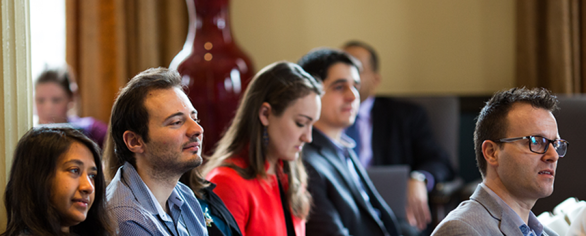 Students taking notes during a cybersecurity symposium